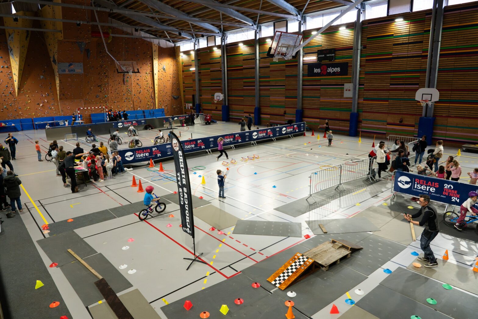 Photo d'un gymnase avec différents stands de sport, pour l'événement terre de jeux 2024 organisée par la commune des deux Alpes